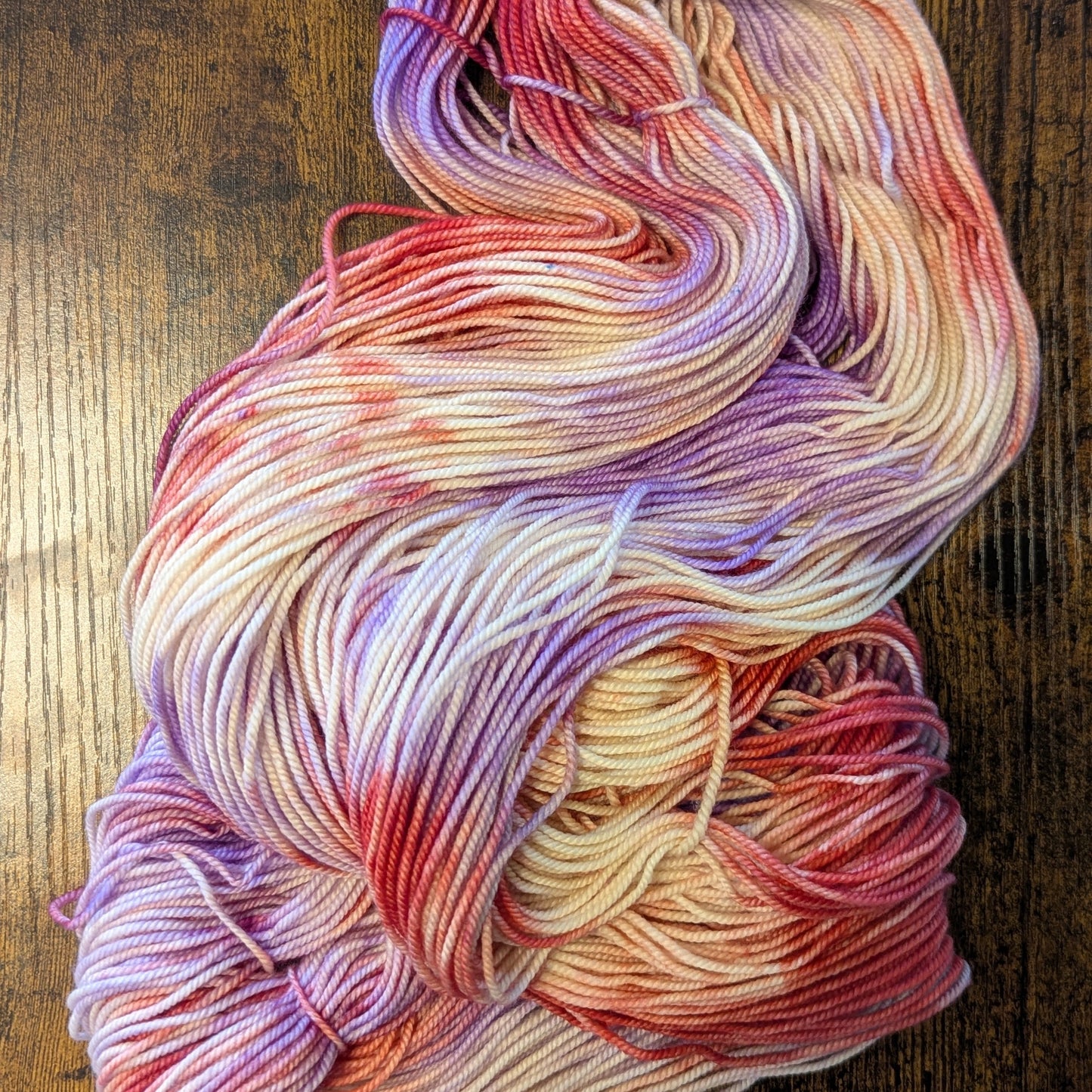 Multicolored yarn skein on a wooden surface