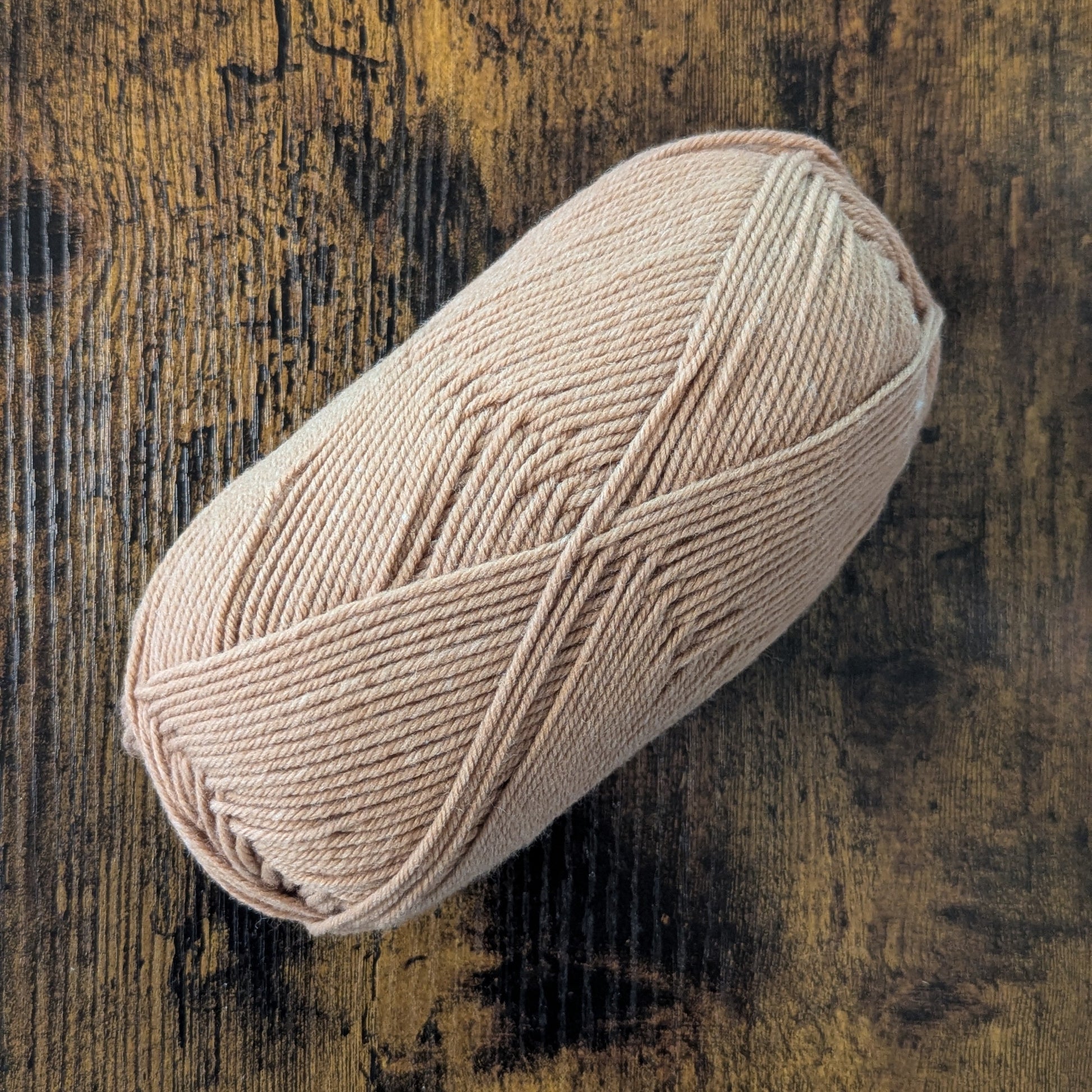 Ball of yarn on a textured wooden surface