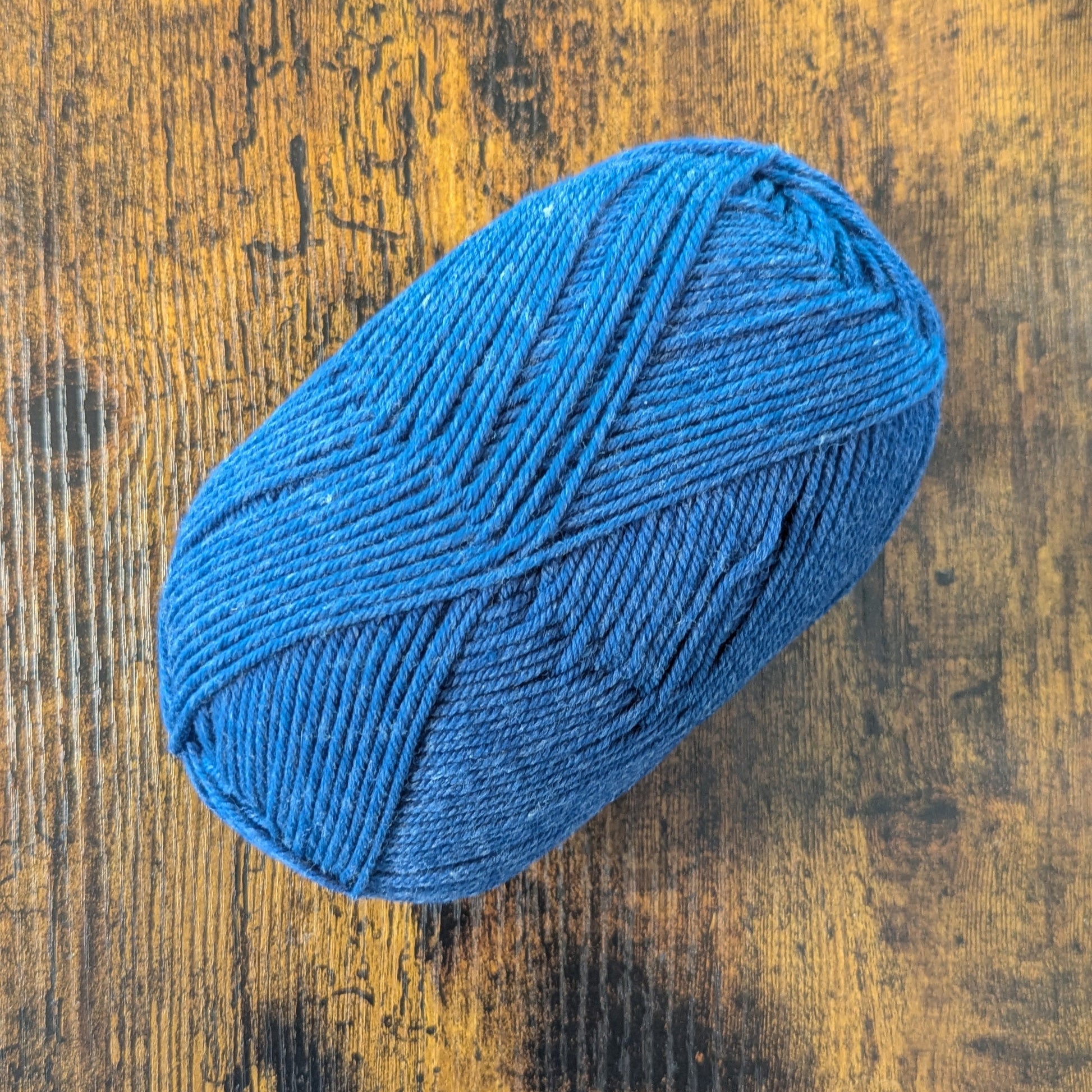 Blue skein of yarn on a wooden surface