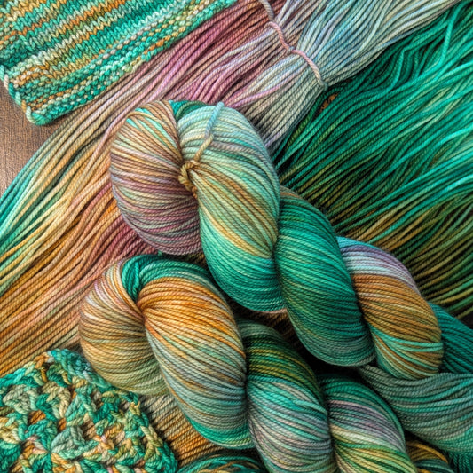 Colorful yarn skeins and a knitted item on a wooden surface